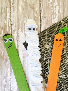 two halloween crafts made out of toilet paper and pencils with eyes, nose and mouth