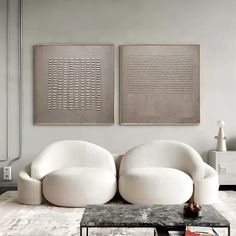 a living room with two white chairs and a coffee table in front of the couch