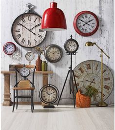 a room with many clocks on the wall and a red lamp hanging from the ceiling