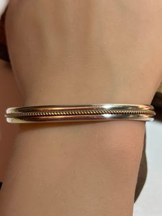 This is a gorgeous, vintage, genuine, handmade Navajo 12K gold-filled and sterling silver cuff bracelet that is handmade by renowned Navajo silversmith Melissa Yazzie. The cuff bracelet features a 12K yellow gold-filled rope in the center with sterling silver design above and below it. Very stunning and well-made. The inner circumference of the bracelet is about 6 1/2 inches including its opening. The gap opening is about 1". The bracelet measures about 2 1/4" by 1 5/8". It has some bend to acco Classic Gold Sterling Silver Cuff Bracelet, Classic 925 Stamped Cuff Bracelet For Anniversary, Gold Sterling Silver Nickel-free Bracelet For Anniversary, Classic Handmade Gold Sterling Silver Bracelet, Classic Gold Sterling Silver Handmade Bracelet, Bohemian Sterling Silver Bangle In Gold, Vintage Gold Sterling Silver Bracelet, Nickel Free, Vintage Gold Sterling Silver Nickel-free Bracelet, Nickel-free Gold Sterling Silver Vintage Bracelet