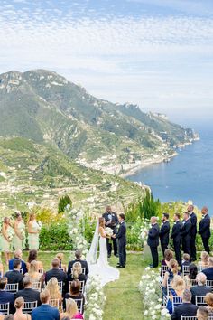 a couple getting married at the end of their wedding ceremony in front of an ocean view