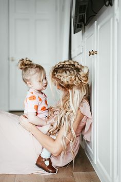 a mother and her daughter sitting on the floor looking at each other