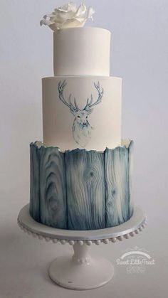 a white and blue cake with a deer head on top