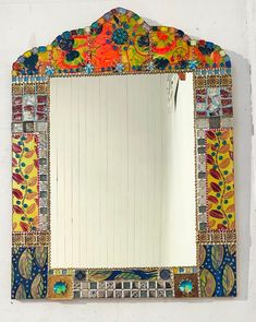 a colorful mirror hanging on the side of a wall