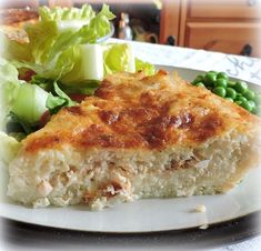 a close up of a plate of food with salad and bread on the other side