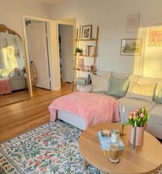 a living room filled with lots of furniture and flowers on the coffee table in front of it