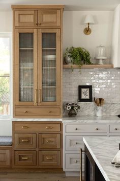 a kitchen with wooden cabinets and marble counter tops