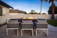 a fire pit sitting on top of a patio next to a couple of couches