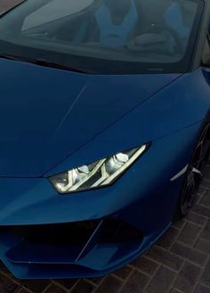 a blue sports car parked in front of a building