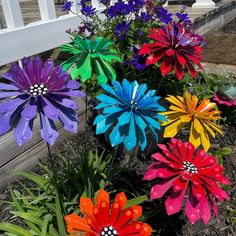 colorful paper flowers are growing in the flower bed on the front porch or lawn area