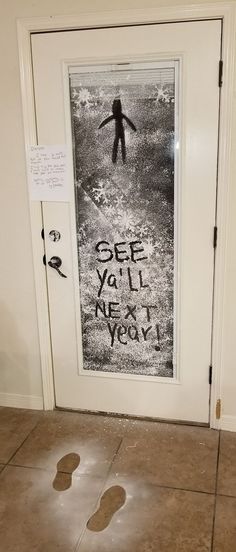 a door that has been decorated with graffiti and some footprints on the ground in front of it