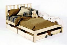 a bed with drawers underneath it and a teddy bear sitting on the bottom one side