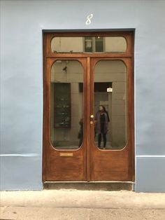 a person standing in the doorway of a building with two doors and one door is open