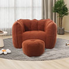 an orange chair and ottoman in a living room with a potted plant on the floor