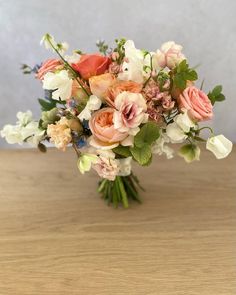 a bouquet of flowers sitting on top of a wooden table