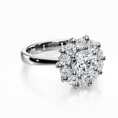 a diamond ring with an oval center surrounded by smaller round diamonds