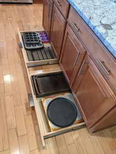 an open drawer in the middle of a kitchen