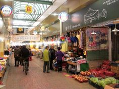 people are shopping at an outdoor market in china