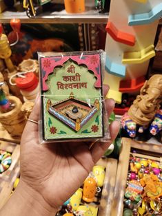 a person holding up a card game in front of many other toys and games on display