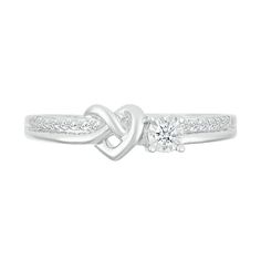 a white gold ring with a heart shaped diamond in the center and side stones on each band