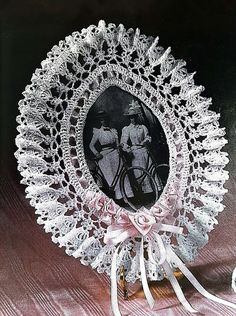 an old photo of two women riding bicycles on a lace doily with ribbon around it