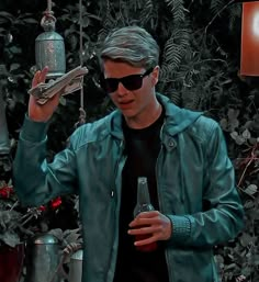 a man wearing sunglasses holding a bottle in his hand