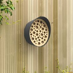 a clock mounted to the side of a wooden wall with holes in it's center