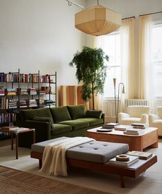 a living room filled with furniture and bookshelves in front of a large window