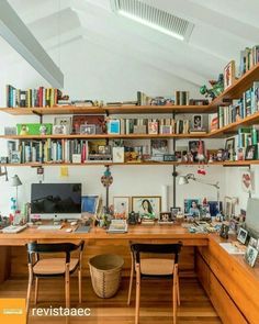 a home office with lots of books on the shelves and desks in front of it