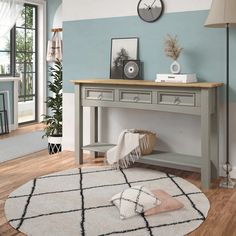 a living room with a rug, table and clock on the wall