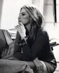 black and white photograph of a woman sitting on a couch with her hand to her mouth