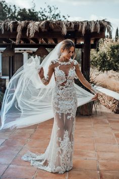 a woman in a wedding dress holding her veil