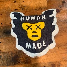 a black and yellow stuffed animal with the words human made on it's face