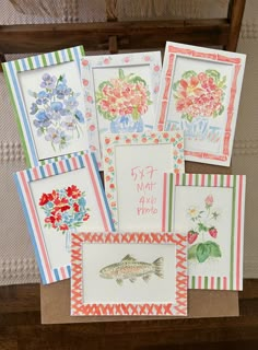 six cards with flowers and fish on them are laid out in front of a chair