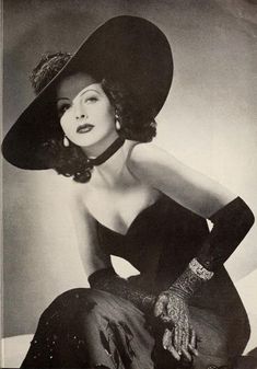 a black and white photo of a woman wearing a hat