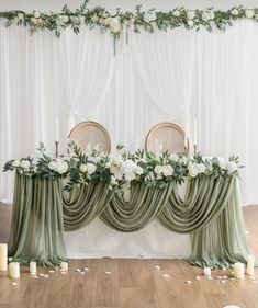 the table is decorated with greenery and white flowers