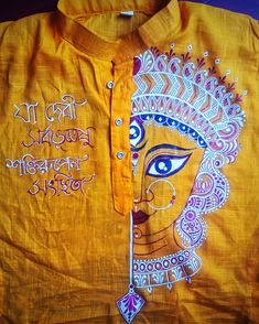 an orange shirt with white writing on the front and side, depicting a woman's face