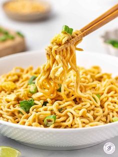 chopsticks holding noodles in a white bowl