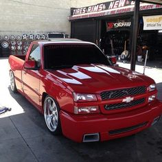 a red truck parked in front of a store