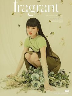 a woman sitting on the ground with flowers in front of her