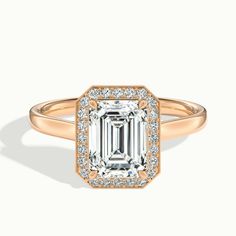 an emerald and diamond ring with diamonds on the band, set in 18k rose gold