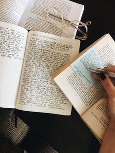 a person is writing on an open book