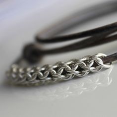 a close up of a silver bracelet on a white surface