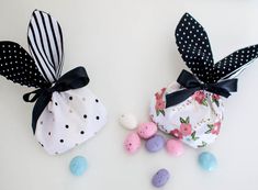 two small bags with black and white polka dots on them next to some colored eggs