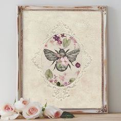 a painting with flowers and a bee in the middle on a shelf next to some white roses