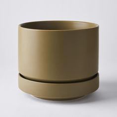 a large beige bowl sitting on top of a white table