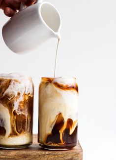 a person pours coffee into two glasses