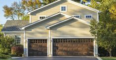 a house with two garages and trees in the background