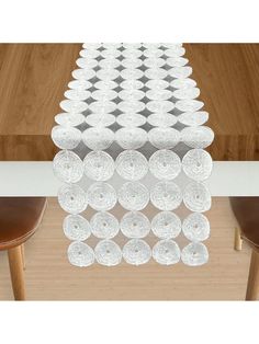 a long table with plates on it in front of a wooden table and two chairs