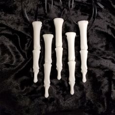 three white candles sitting on top of a black blanket